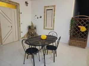 a black table with chairs and a yellow ball on it at A due passi dal mare in Ribera