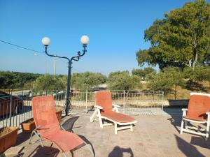 three chairs and a street light on a patio at A due passi dal mare in Ribera