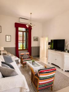 a living room with a couch and a tv at Wisteria Lodge by Veneto Villa in Albignasego