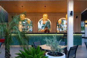 a restaurant with tables and chairs and a bar at Kantary Beach Hotel Villas & Suites in Khao Lak