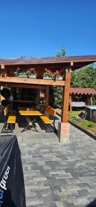 a picnic table and chairs under a pavilion with flowers at Cabana Relax in Râmnicu Vâlcea
