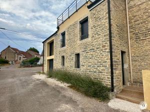 a brick building with a balcony on the side of it at Le Creux Percé in Pasques