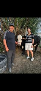 a man and a woman standing next to two cows at Dosoi Guest House Experience Song-Kul with Horseback Tours in Kyzylemgek