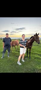 a man and a woman standing next to a horse at Dosoi Guest House Experience Song-Kul with Horseback Tours in Kyzylemgek