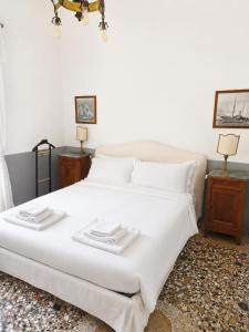a bedroom with a large white bed with two tables at Wisteria Lodge by Veneto Villa in Albignasego
