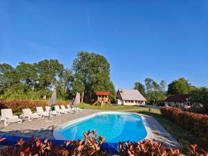 a swimming pool with lounge chairs and a playground at Liki Niki Spa in Gospić