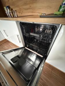 a dishwasher with its door open in a kitchen at Chata na Karpackiej in Kostrzyca