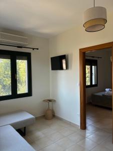 a room with a bed and a tv on the wall at Two Mills Apartments in Myrina