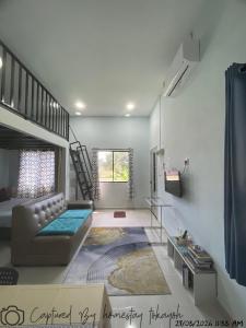 a living room with a couch and a staircase at Homestay Studio TOKAYOH in Kota Bharu
