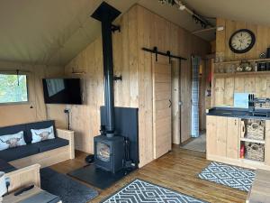 a living room with a stove in a room at Ecosse Glamping in Crossford