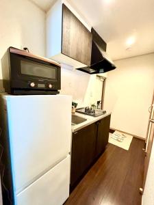 a kitchen with a microwave on top of a refrigerator at Norah Stay Tokyo in Yashio +20 photos