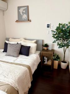 a bedroom with a bed and a potted plant at Norah Stay Tokyo in Yashio