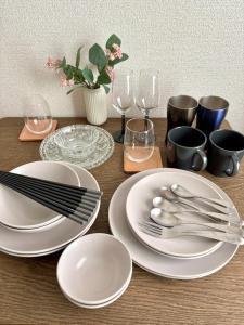 a table with white plates and silverware on it at Norah Stay Tokyo in Yashio