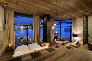 a living room with white furniture and large windows at Wiesergut in Saalbach-Hinterglemm