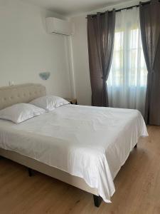 a white bed in a bedroom with a window at Barbe Bleue 1982 in Bridoré