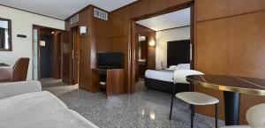 a hotel room with a bed and a television at Goldstar Resort & Suites in Nice
