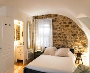 a bedroom with a bed and a stone wall at "La Voûte de Pierre" Gîte indépendant in Saint-Cyr