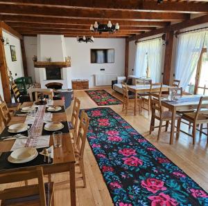 a dining room with tables and chairs and a fireplace at Casa din Susani in Călineşti +39 photos
