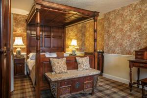 a bedroom with a bed with a wooden frame at Tweeddale Arms Hotel in Gifford