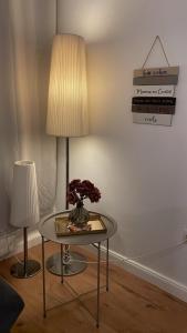 a table with a lamp and a vase of flowers on it at Museums Quartier 0608 in Vienna