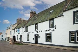 a white building with a sign that reads the twelve arms hotel at Tweeddale Arms Hotel in Gifford