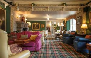 a living room with couches and a fireplace at Tweeddale Arms Hotel in Gifford +1 photo