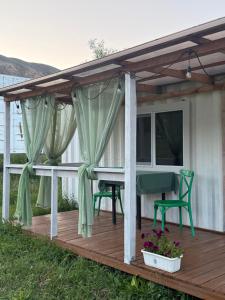 a pergola with a table and chairs on a deck at Qurmety camp in Kurmenty