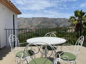 a table and chairs on a balcony with mountains at El Planet - Apartamento con terraza in Benimantell