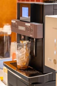 a coffee machine with a drink in a glass at Monday Mansion Hotel in Seoul
