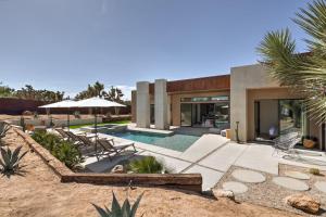a home with a swimming pool and a house at Windsong Modern compound w pool spa in Yucca Valley