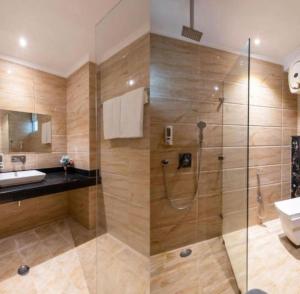 a bathroom with a shower and a toilet and a sink at Hotel Airport Hilton Sky IGI Delhi Airport Terminal 3 With- Free Airport Pickup in New Delhi +17 photos