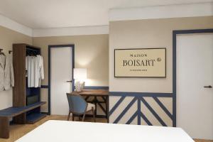 a bedroom with a desk and a dressing room at Hôtel de l'Europe by HappyCulture in Strasbourg