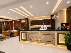 a man standing behind a counter in a hotel lobby at Hotel Airport Hilton Sky IGI Delhi Airport Terminal 3 With- Free Airport Pickup in New Delhi