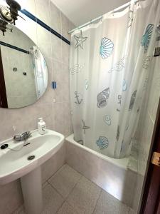 a bathroom with a sink and a shower curtain at Adosado Mar i Pins in Benicarló +17 photos