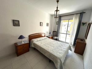 a bedroom with a bed and a lamp on a night stand at Adosado Mar i Pins in Benicarló