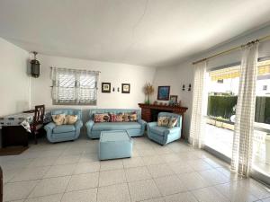 a living room with two blue couches and a window at Adosado Mar i Pins in Benicarló