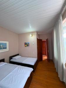 a bedroom with two beds and a window with a door at hotel shomari in Grigoleti