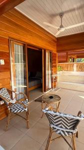 a patio with two chairs and a table and a couch at The Tree Poolbar&Resort in Gili Islands
