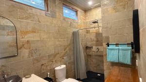 a bathroom with a shower and a toilet and a sink at The Tree Poolbar&Resort in Gili Islands +69 photos