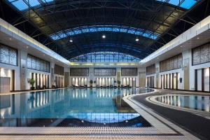 ein großes Schwimmbecken in einem Gebäude mit einer Decke in der Unterkunft DoubleTree by Hilton Shenyang in Shenyang
