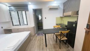 a small room with a bed and a desk and a kitchen at Căn hộ Na Uy in Nha Trang +33 photos