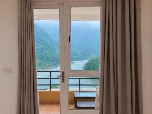 a room with a window with a view of the ocean at Aloha Serenity By Evara -Ganga View Stays in Rishīkesh