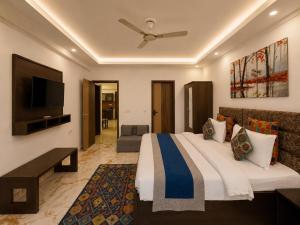 a bedroom with a large bed and a flat screen tv at Aloha Serenity By Evara -Ganga View Stays in Rishīkesh