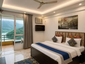 a bedroom with a large bed and a balcony at Aloha Serenity By Evara -Ganga View Stays in Rishīkesh +40 photos
