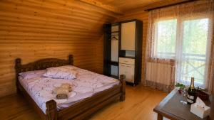 a bedroom with a bed with a teddy bear on it at Mountain House in Mykulychyn
