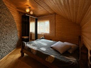 a bedroom with a bed in a wooden room at Mountain House in Mykulychyn