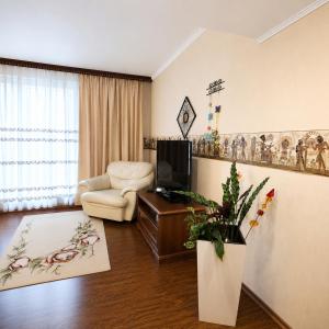 a living room with a tv and a chair and a couch at Ventas in Liepāja