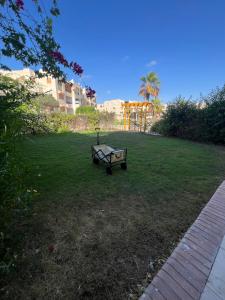 a park bench sitting in the middle of a yard at Apres-midi in Dawwār Abū Maḩrūs