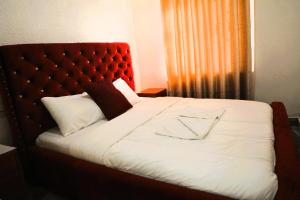 a bedroom with a large bed with a red headboard at Choice Lounge in Rubavu +10 photos