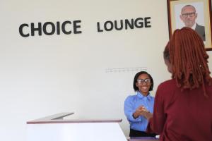 a woman standing under the choice lounge sign at Choice Lounge in Rubavu